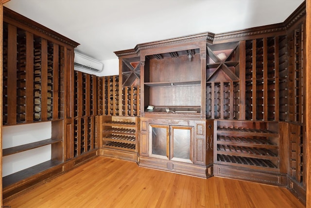 wine room with an AC wall unit and light hardwood / wood-style flooring