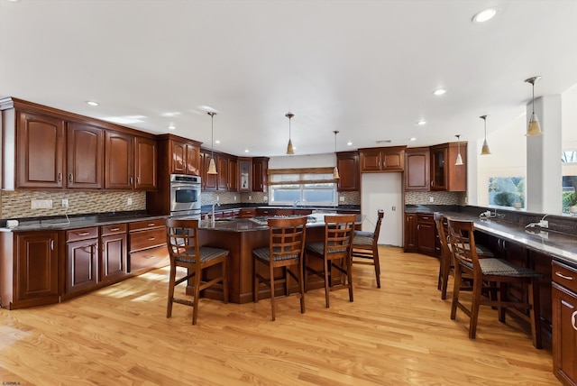 kitchen featuring a breakfast bar, light hardwood / wood-style floors, and hanging light fixtures