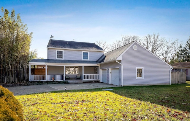 back of property with a lawn, covered porch, and a garage