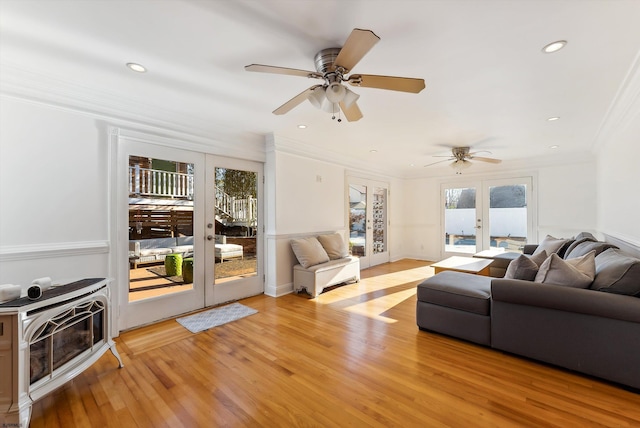 living room featuring ceiling fan, light hardwood / wood-style floors, crown molding, and french doors