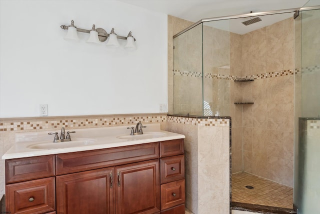 bathroom with vanity, a tile shower, and tile walls