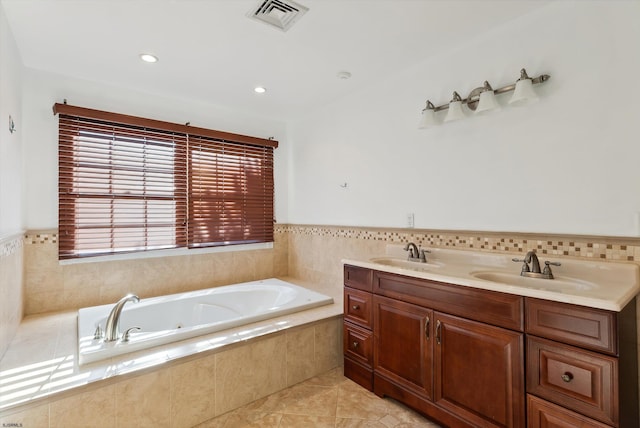 bathroom with tile patterned flooring, vanity, and a relaxing tiled tub