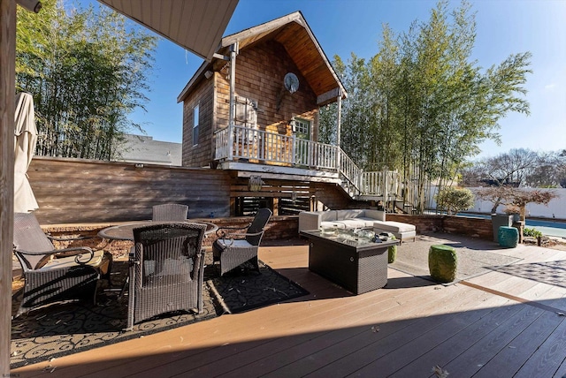 wooden deck featuring an outdoor living space with a fire pit