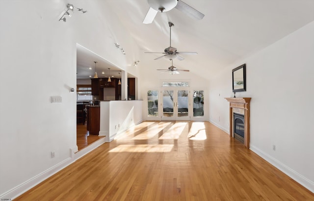 unfurnished living room featuring ceiling fan, light hardwood / wood-style floors, and high vaulted ceiling