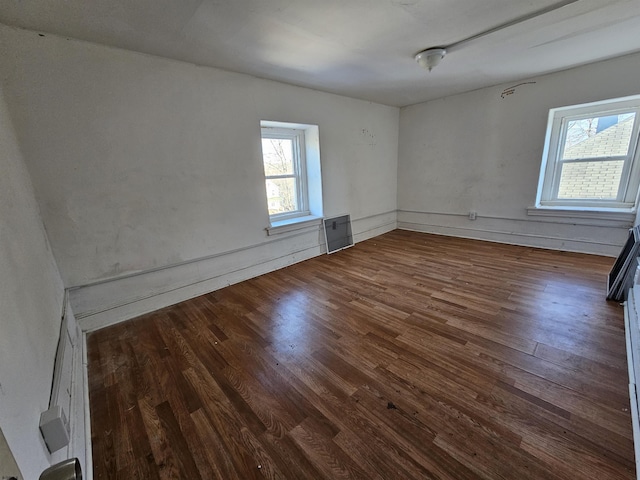 unfurnished room featuring a healthy amount of sunlight and dark hardwood / wood-style flooring