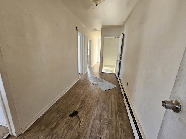 hallway with baseboard heating and dark hardwood / wood-style flooring