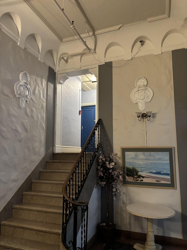 stairway featuring hardwood / wood-style floors and ornamental molding