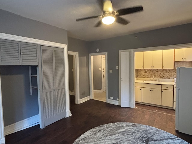 kitchen with ceiling fan, sink, dark hardwood / wood-style floors, white fridge, and decorative backsplash