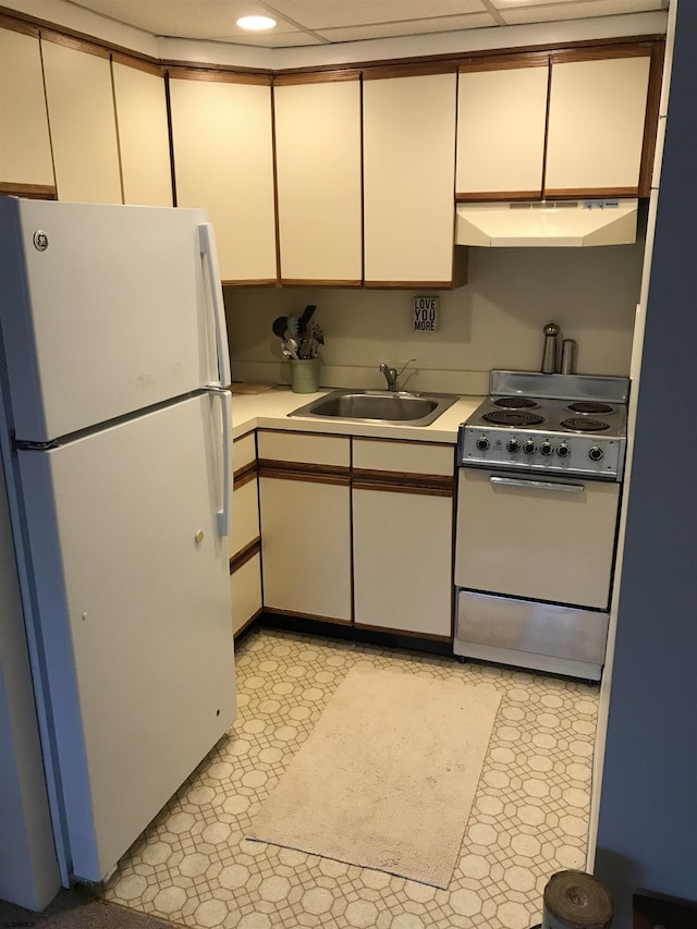 kitchen with stove, white fridge, and sink