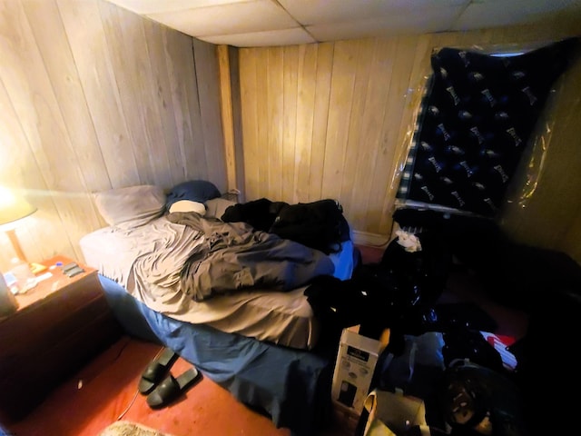 bedroom with wood walls and a drop ceiling