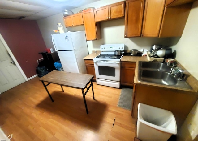 kitchen featuring white appliances, sink, and light hardwood / wood-style flooring