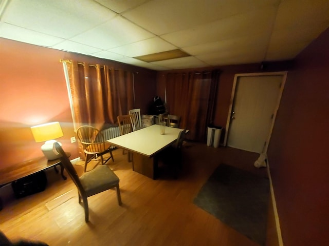 living area featuring a drop ceiling and hardwood / wood-style flooring