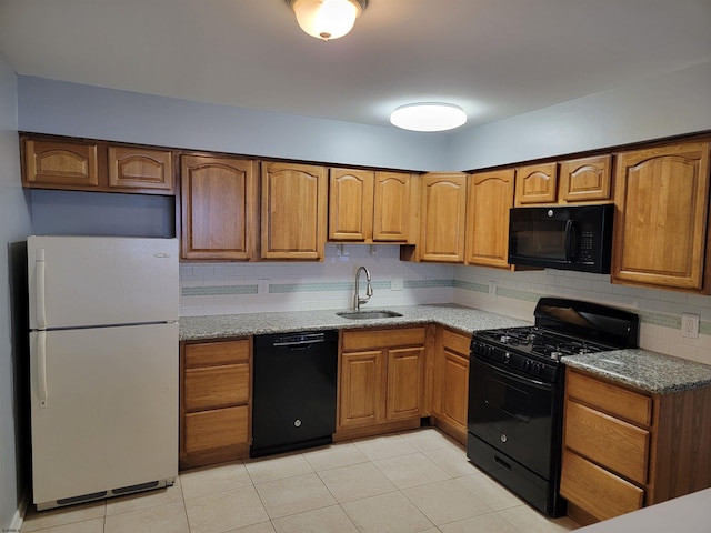 kitchen with stone counters, sink, backsplash, light tile patterned floors, and black appliances