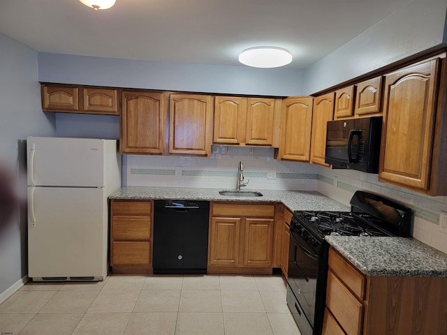 kitchen with backsplash, black appliances, sink, light tile patterned flooring, and light stone counters