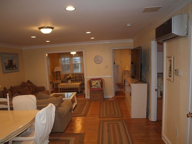 living room featuring an AC wall unit, crown molding, and wood-type flooring