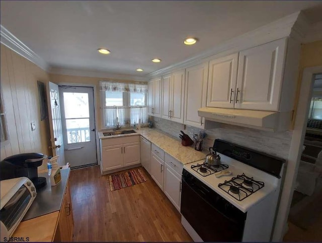 kitchen with white appliances, ventilation hood, sink, white cabinets, and hardwood / wood-style floors