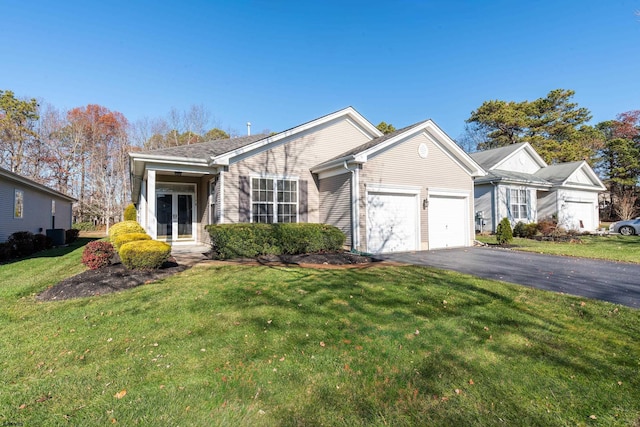 ranch-style house featuring french doors, a garage, and a front lawn