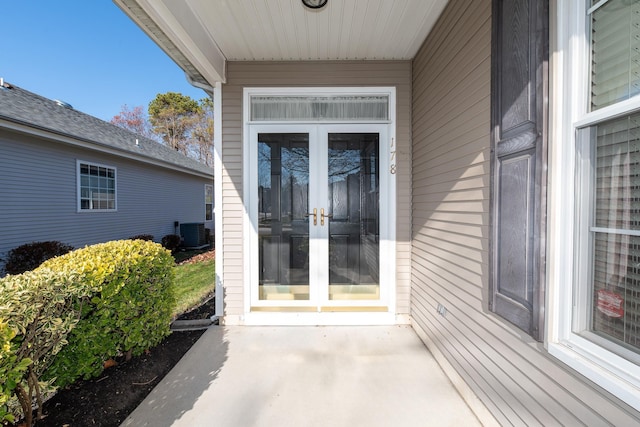 property entrance with french doors, cooling unit, and a patio