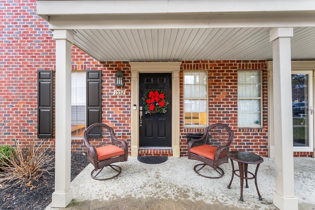 view of exterior entry featuring covered porch