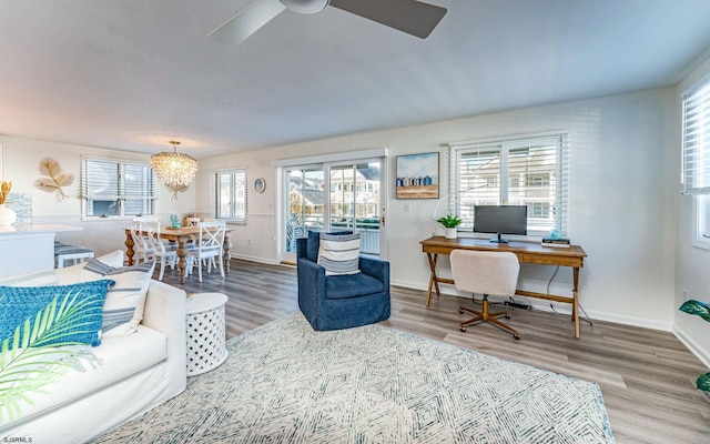 living room featuring hardwood / wood-style flooring, ceiling fan with notable chandelier, and a wealth of natural light