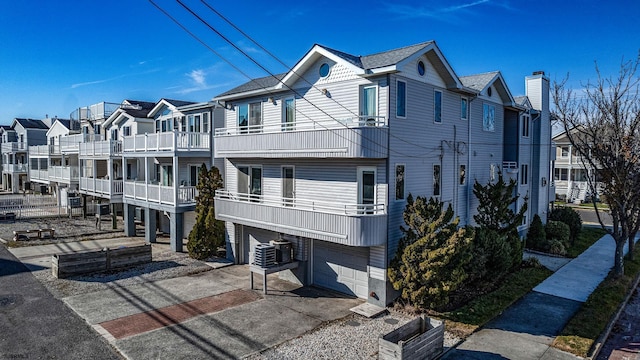 exterior space with a balcony, a garage, and central AC unit