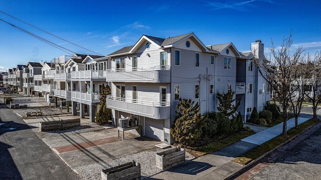 exterior space featuring central AC, a balcony, and a garage