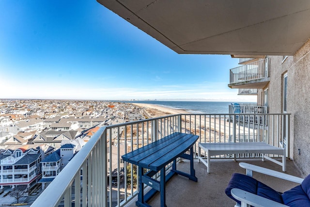 balcony featuring a view of the beach and a water view