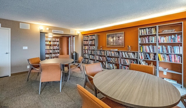 dining space with carpet floors and a textured ceiling