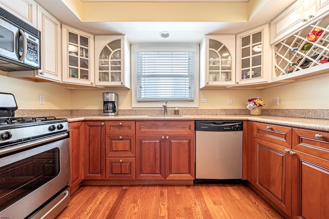 kitchen with sink, stainless steel appliances, and light wood-type flooring