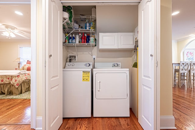 laundry area featuring ceiling fan, cabinets, light wood-type flooring, washer and dryer, and ornamental molding