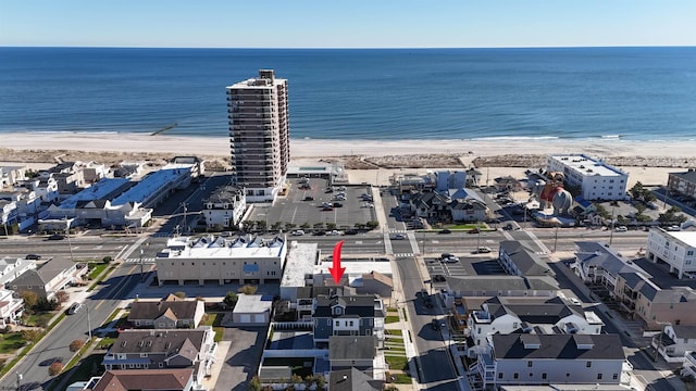 drone / aerial view featuring a beach view and a water view