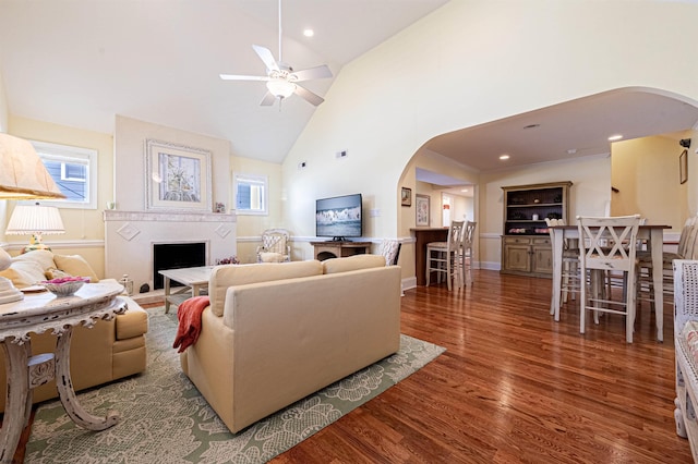 living room featuring dark hardwood / wood-style floors, high vaulted ceiling, and ceiling fan