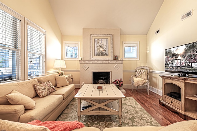 living room featuring a healthy amount of sunlight, dark hardwood / wood-style flooring, and lofted ceiling