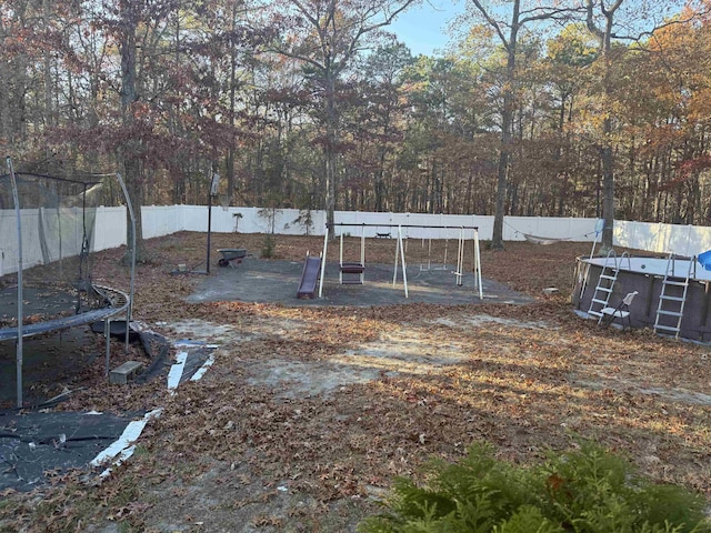 view of yard with a playground and a trampoline