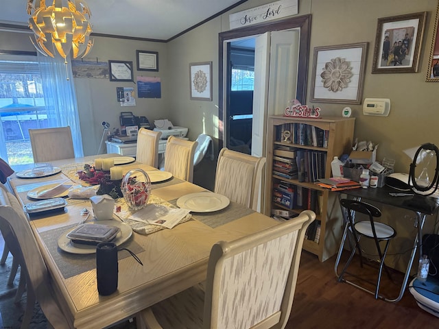 dining area with plenty of natural light, lofted ceiling, dark wood-type flooring, crown molding, and a notable chandelier