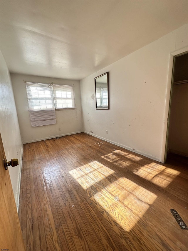 unfurnished bedroom with wood-type flooring and a closet