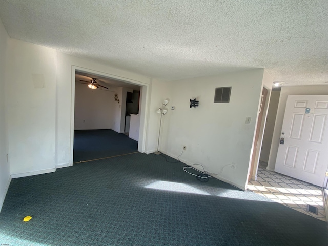 unfurnished room featuring a textured ceiling, carpet floors, and ceiling fan