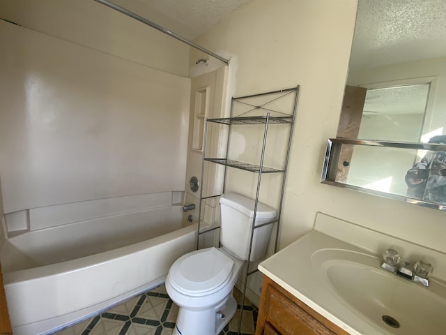 full bathroom featuring vanity, a textured ceiling, toilet, and shower / washtub combination