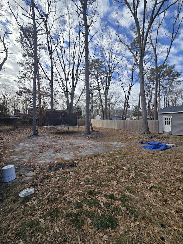 view of yard featuring a storage shed and a trampoline