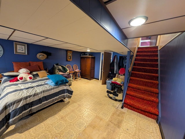 bedroom with light floors and a paneled ceiling