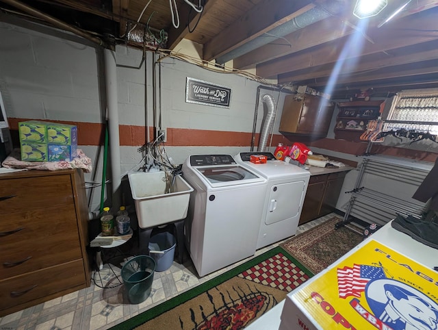 laundry room with cabinet space, a sink, and washer and clothes dryer