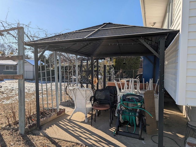 view of patio / terrace featuring a shed, fence, and a gazebo