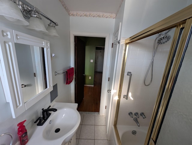 full bathroom with tile patterned flooring, bath / shower combo with glass door, and a sink