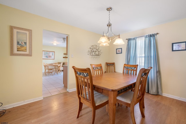 dining space with a notable chandelier and light wood-type flooring