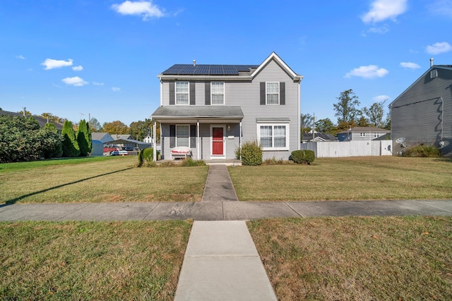 view of front of property featuring covered porch, solar panels, and a front lawn