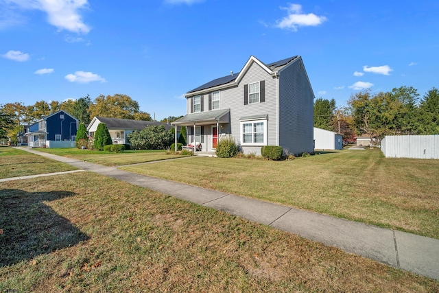 view of property featuring a front yard, a porch, and solar panels