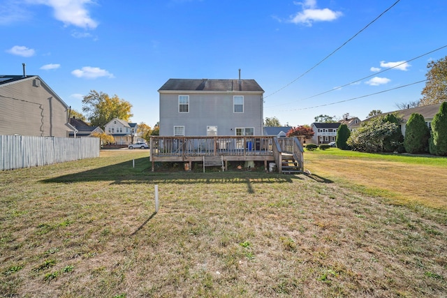 back of house featuring a lawn and a wooden deck