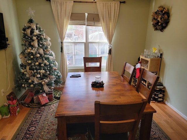 dining space with baseboards and wood finished floors