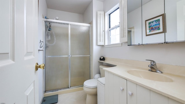 bathroom with tile patterned floors, a shower with door, vanity, and toilet