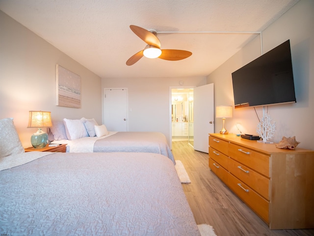 bedroom with ceiling fan, ensuite bathroom, and light hardwood / wood-style floors